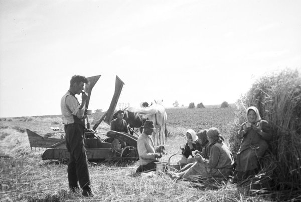 Pause der Erntehelfer auf dem Feld der Domäne Blankenfelde mit einem Krupp Getreide - Mähwerk.